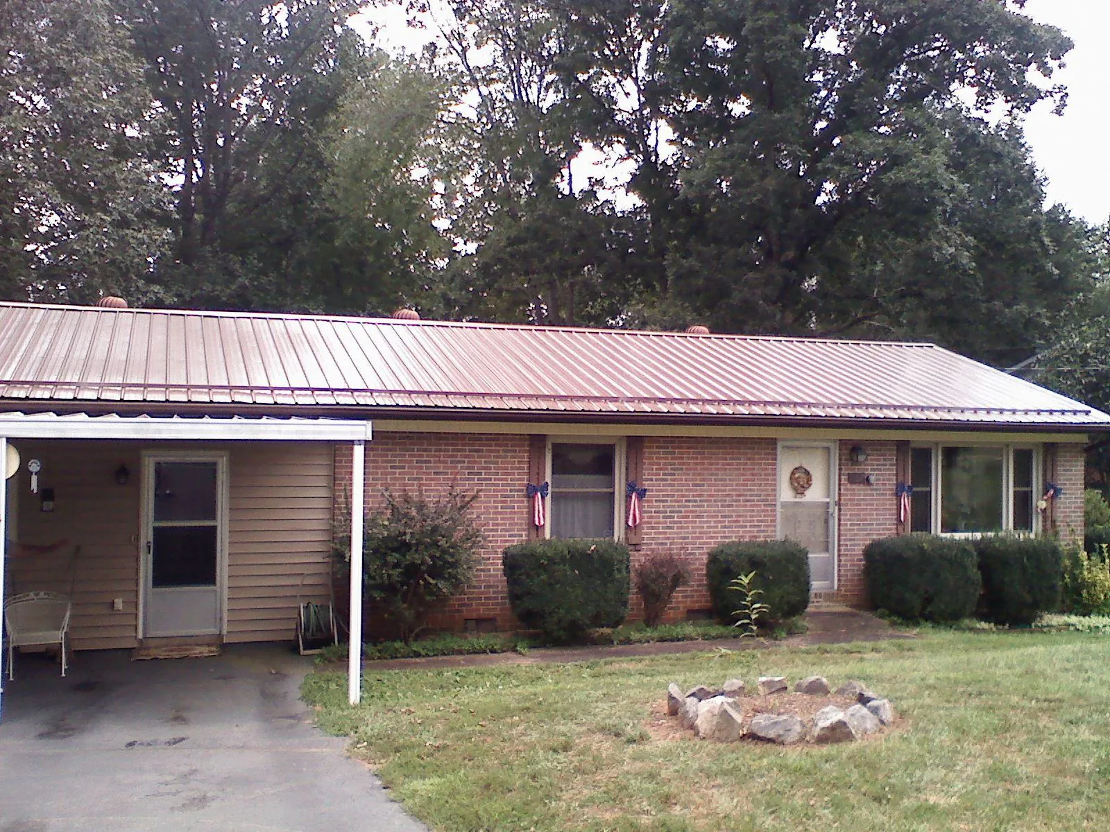 Bronze metal roof and carport on a brick ranch home — Roof Repair work by our crew in Westminster